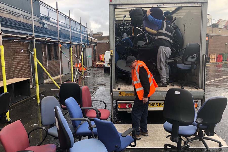 Chairs being loaded into a van for disposal after an office clearance