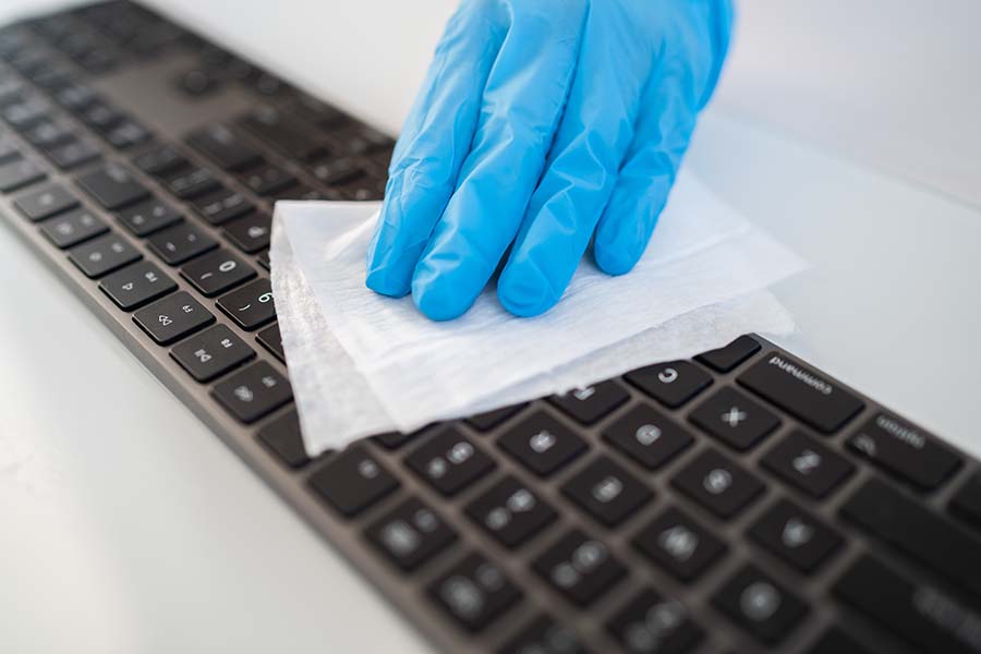 Disinfecting wipes to wipe surface of desk, keyboard, mouse at office