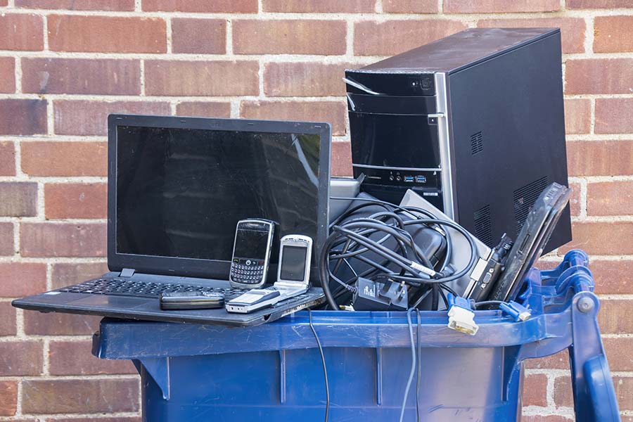 Old computer hardware and mobile devices put into a recycling container