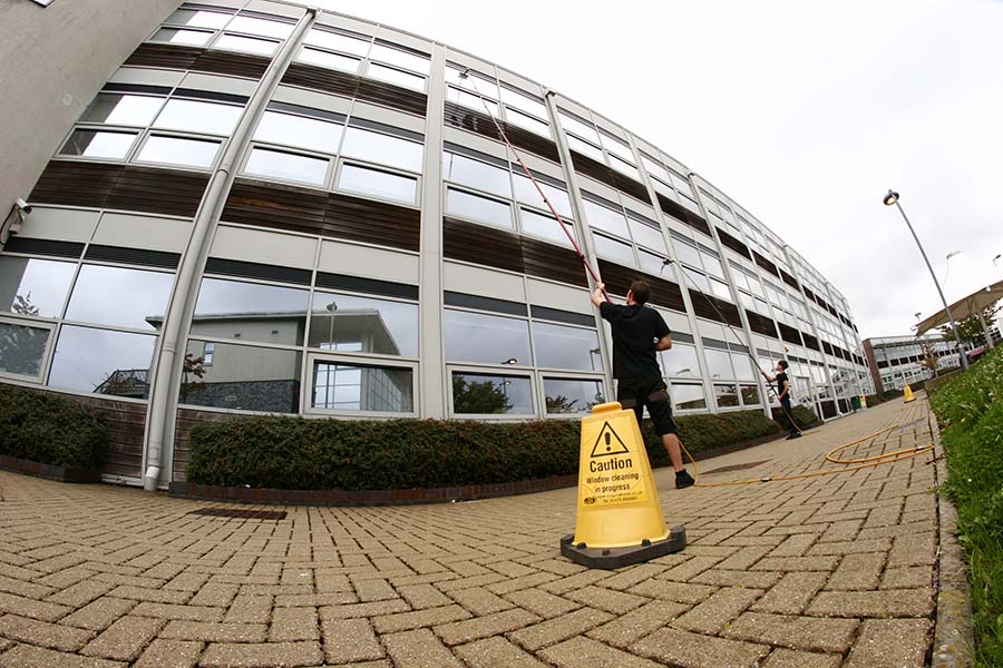 A contractor cleaning the windows of a office or school building