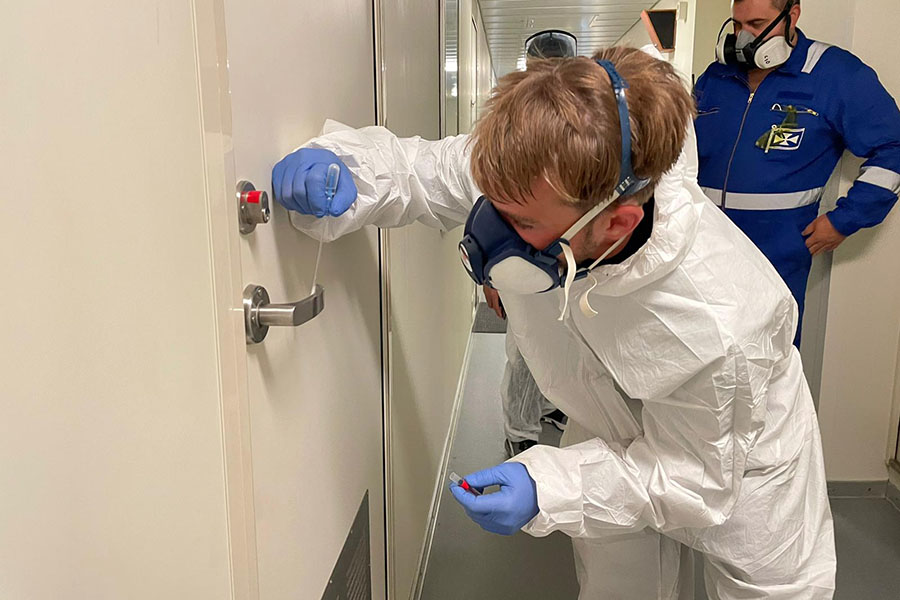 A technician swabbing a door handle to ensure it has been properly cleaned