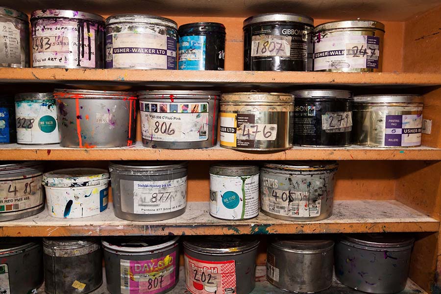 A shelf containing various empty pots of paint